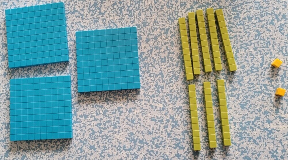 Base ten blocks showing three hundred and eighty two 